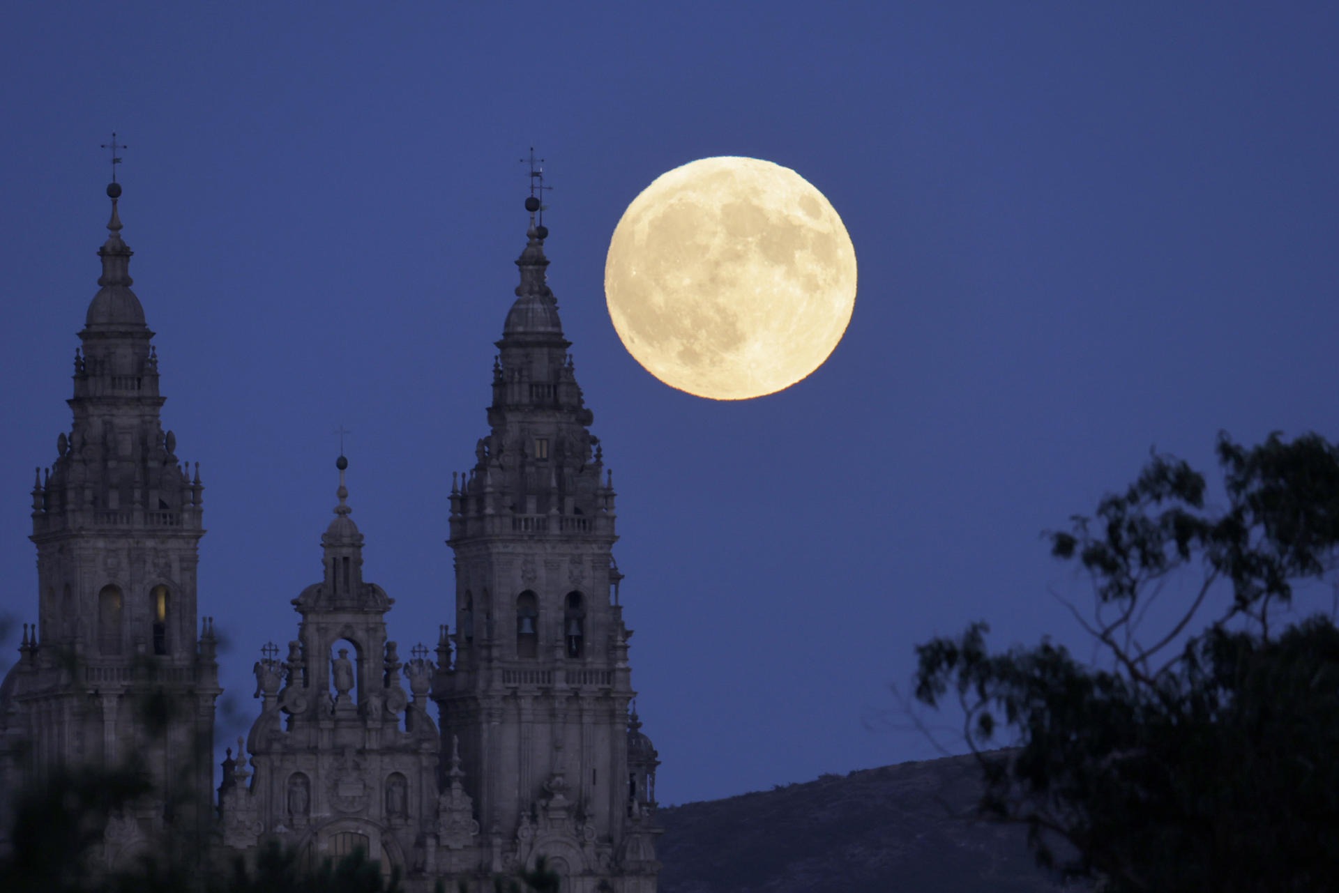 SANTIAGO DE COMPOSTELA, 17/09/2024.- La luna llena sale hoy sobre la catedral de Santiago de Compostela. La segunda de las cuatro superlunas que se van a registrar este año mostrará la próxima madrugada un pequeño eclipse parcial que se apreciará a la vista como un pequeño mordisco al disco lunar y que será visible a simple vista de África, Europa y América. EFE/Lavandeira jr