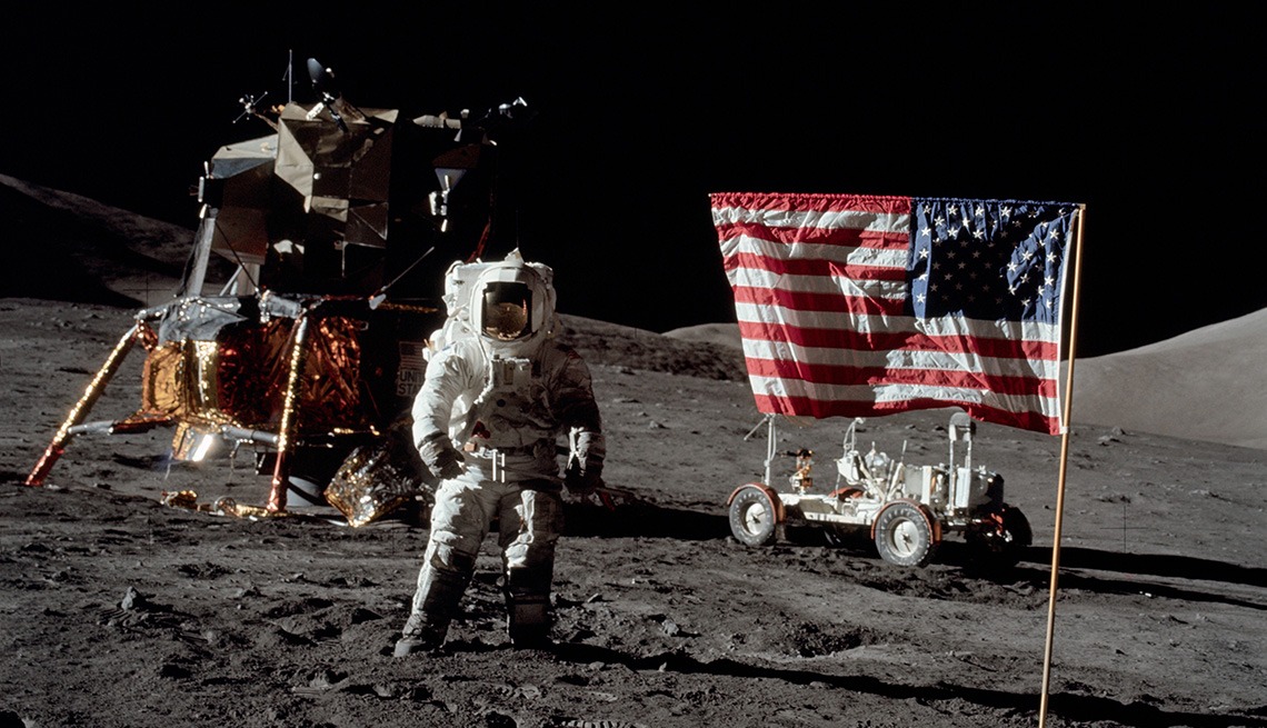 Se observa un astronauta junto a la bandera de Estados Unidos