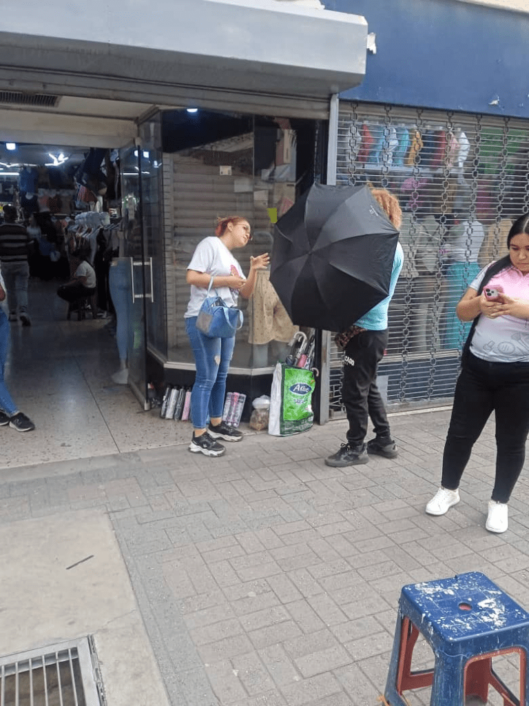 Las personas se le acercan a comprar paraguas